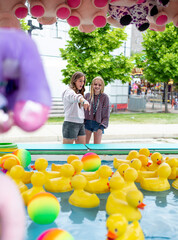 Two teen girls ready to play some fun carnival games. Teenage friends having fun at the fair. 