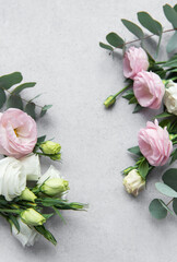 Elegant arrangement of soft pastel flowers with eucalyptus leaves on a light gray background