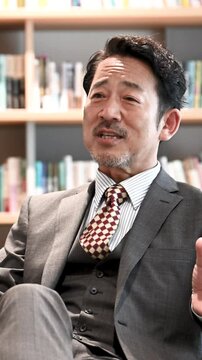 Image of a vertical video of a cool Asian (Japanese) president sitting in a chair talking in an interview, etc.