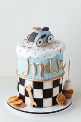 Beautiful tall two tier fondant cake on the white background. Birthday cake for a little boy named...