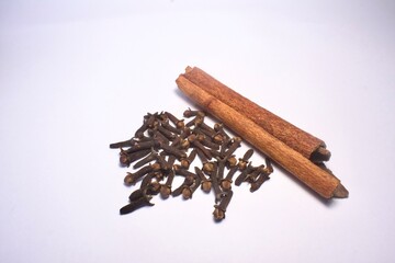 cinnamon sticks and cloves on white background