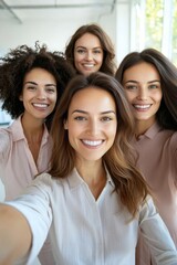 Obraz premium Female-led team taking a selfie in a bright and modern office, empowered women, leadership and teamwork, casual office attire