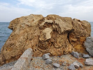 Calcite perennial mountain against the background of the sea. Limestone mountain.