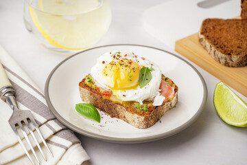 Plate of tasty sandwich with egg on grey background