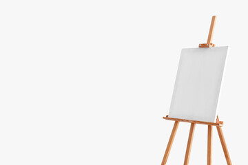 Wooden easel with blank canvas near grey wall