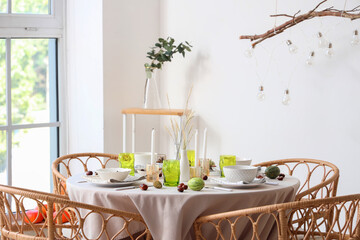 Autumn table setting decorated for Thanksgiving Day with pumpkins and chestnuts in light dining room