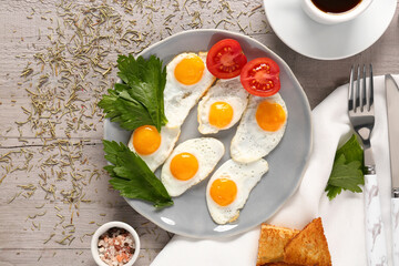 Composition with tasty fried quail eggs, spices and toasts on grey wooden background