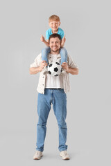 Young father and little son with soccer ball on white background