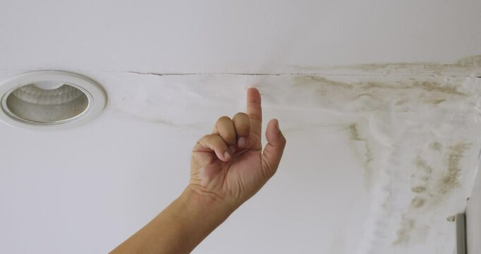 Male finger is peeling paint on ceiling, Office building or house problem for house service. High definition shot at 4K video footage.