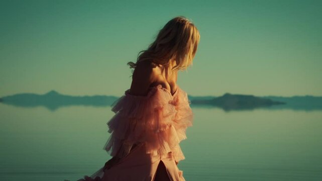 Model poses in stunning gown against serene sunset landscape water