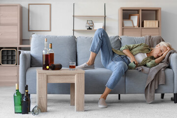 Drunk mature woman lying on sofa. Concept of alcoholism