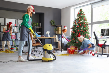 Female janitors cleaning office after Christmas party