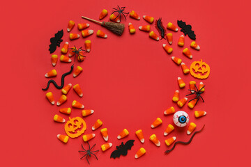 Frame made of Halloween toys and candies on red background