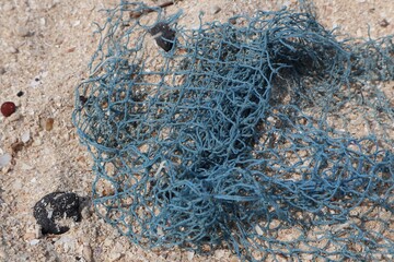 Naklejka premium Close up of pieces of fishing net on beach sand