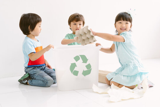 Group of Kids Students happy diversity in school for child picking up the garbage and putting it in recycling bin in classroom at Kindergarten school. Recycling, Ecology protection concept.