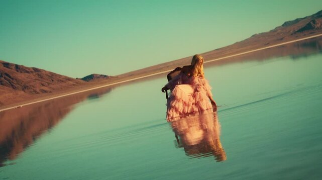 Model showcases bizzare gown by the water during sunset at scenic location