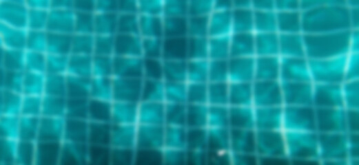 Blurred image of water and tiles in pool. Water waves and reflection in swimming pool