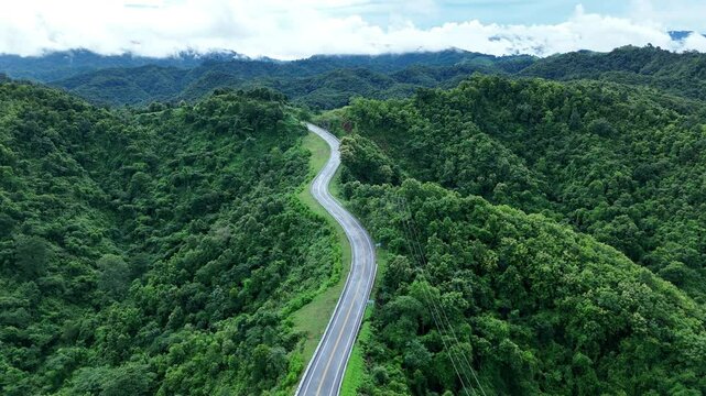 Video footage from a drone camera angle at Loi Fah Road, road in Nan Province, Thailand. It winds through the ridge of the forest. The view is very beautiful. It's green in the rainy season.