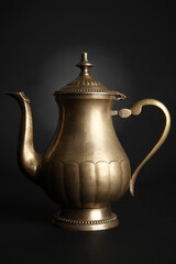 Metal vintage teapot on black background