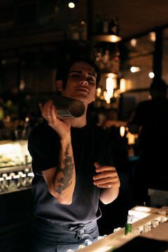 Attractive young man bartender making cocktail in a night bar.