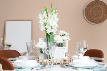 Table setting with white Gladiolus flowers in room