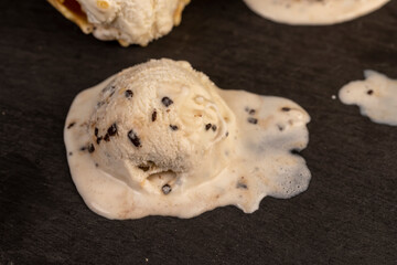 creamy ice cream with pieces of chocolate on a black slate