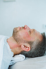 Naklejka premium Male cosmetology. A man lies at a cosmetologist for a facial treatment.
