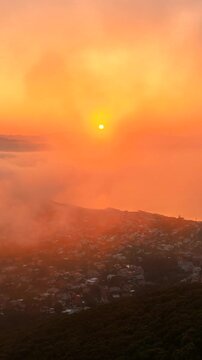 Volando sopra le nuvole all'alba con il sole giallo che spunta.
Ripresa aerea tra le nuvole, sole, mare e montagna. San Felice Circeo, Lazio, Italia.  Video verticale.