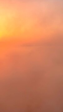 Volando sopra le nuvole all'alba con il sole giallo che spunta.
Ripresa aerea tra le nuvole, sole, mare e montagna. San Felice Circeo, Lazio, Italia.  Video verticale.