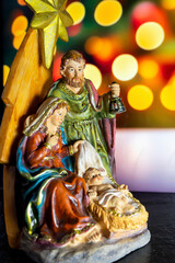 Fototapeta premium Christmas nativity scene with baby Jesusand Joseph in front of bokeh background