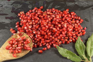 pomegranate seeds on black slate background