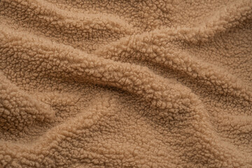 Soft, textured beige fabric draping over a surface in warm lighting during the afternoon