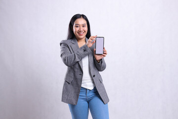 charm young beautiful office girl cheerful to camera both hands holding sideways showing cellphone screen wearing gray suit isolated on white background. for technology, lifestyle, promotion content