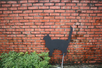 red bricks wall with a black cat element design for vintage concept