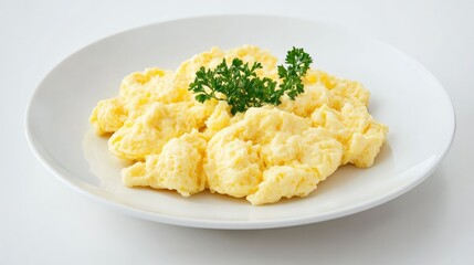 Light and airy scrambled eggs, delicately arranged on a white plate, set against a pristine white backdrop for a fresh breakfast look.