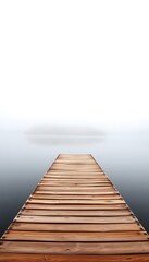 Fototapeta premium A weathered wooden pier extends out into a still, foggy lake, with trees displaying brilliant autumn colors lining the far shore.