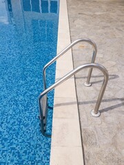 Naklejka premium Ladder poolside with clean blue water