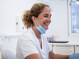 A dental hygienist is joyfully interacting with a patient during a routine check-up, showcasing a warm and welcoming environment in the clinic.
