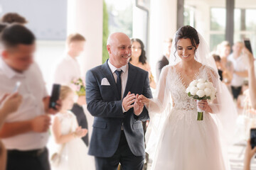 Happy father leading his daughter to the altar. Dad is proud of his beautiful daughter. Wedding ceremony