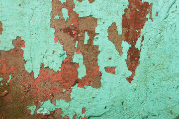 Grunge wall texture background. Paint cracking off dark wall with rust underneath