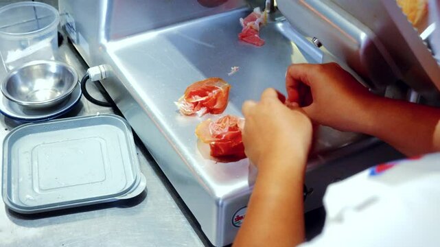 Authentic Italian food making process in traditional Italian restaurant, of smoked ham Coppa being sliced and prepared
