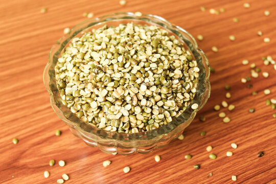 Split Mung Bean Lentils Also Know as Mungbean, Mung Gram, Vigna Radiata, Green Gram, Golden Gram Legumes, Moong Bean, Moong Dal, Green Bean or Mung Daal in bowl on wooden background
