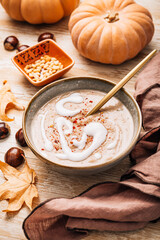 Creamy sweet chestnuts and pumpkin soup with seeds and cream