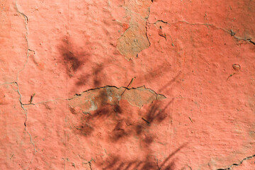 Cracked paint on wall building background, acrylic red paint damaged and cracked on ground wall.