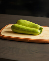 Two Fresh Zucchini on a Cutting Board Close-Up on Dark Background