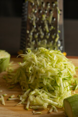 Shredded Zucchini on a Cutting Board Close-Up on Dark Background