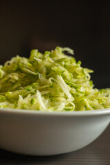  Shredded Zucchini in a White Bowl Close-Up on Dark Background