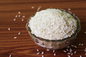 White rice in bowl on wooden background