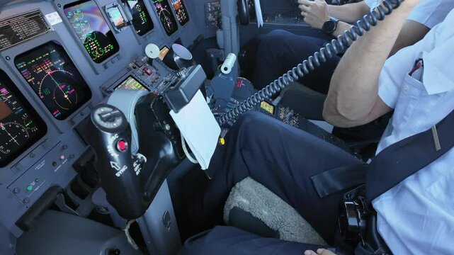 Left view inside a jet cockpit of a pilot using the hand microphone to address the passengers. 4K 60FPS