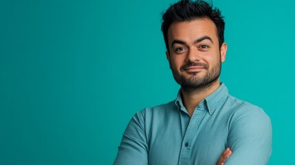 Fototapeta premium A man with a beard and mustache is wearing a blue shirt and is smiling
